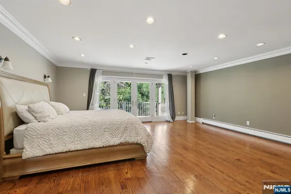 a bedroom with a large bed and wooden floor