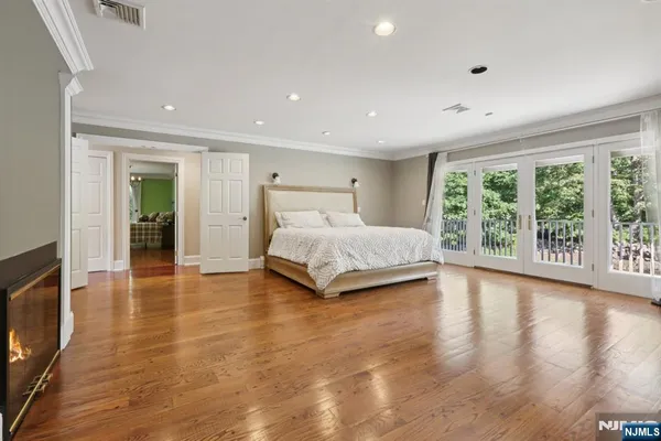 a spacious bedroom with a large bed and a flat tv screen