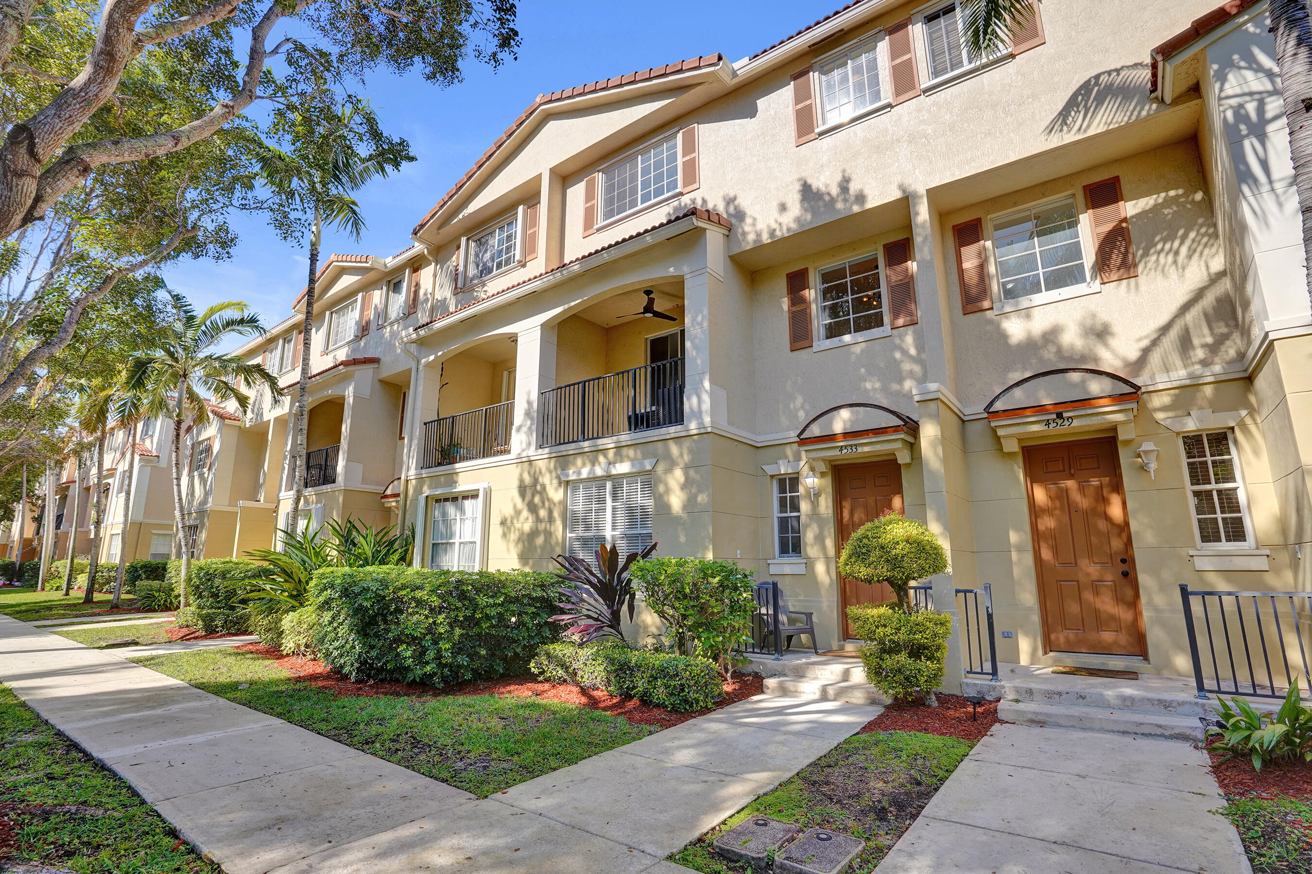 a front view of a multi story residential apartment building with yard and outdoor seating