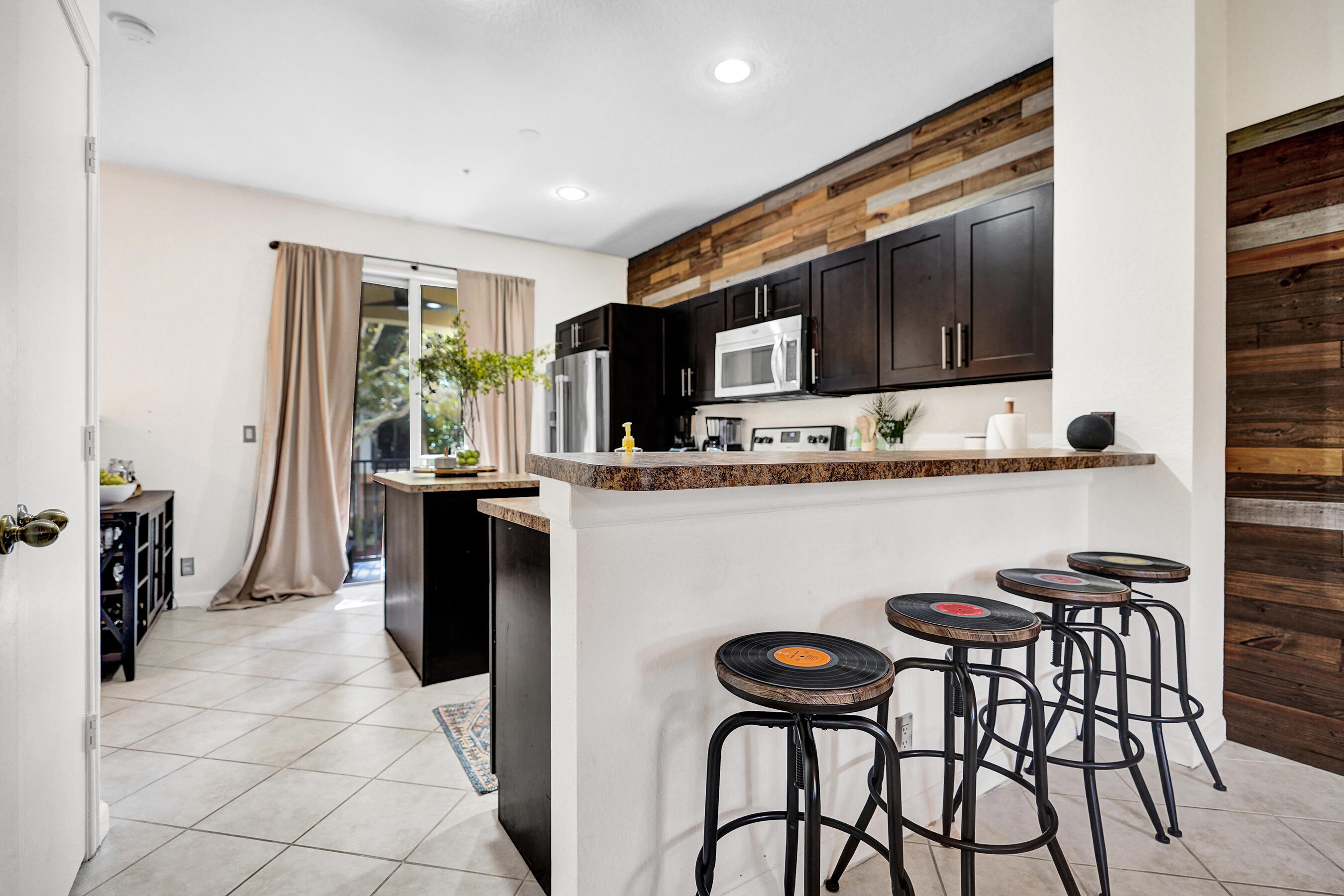 4533 Danson Way Delray Beach, FL 33445 - Photo 15 of 88 a kitchen with stainless steel appliances kitchen island granite countertop a table chairs and a refrigerator