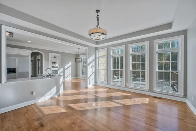 a view of a livingroom with a chandelier fan and windows