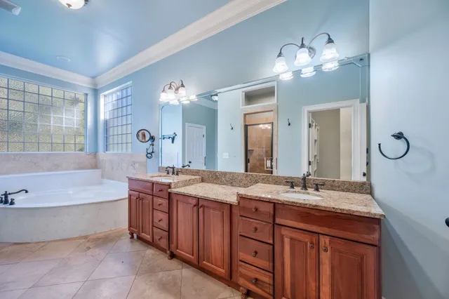 a bathroom with a granite countertop toilet a sink a mirror and a shower