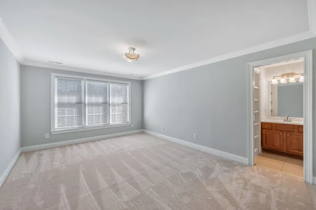 a view of an empty room with wooden floor and ceiling fan