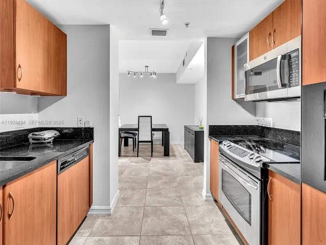 a kitchen with stainless steel appliances granite countertop a stove a microwave and a refrigerator