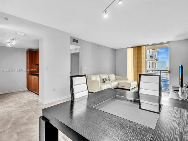 a living room with furniture a flat screen tv and a window