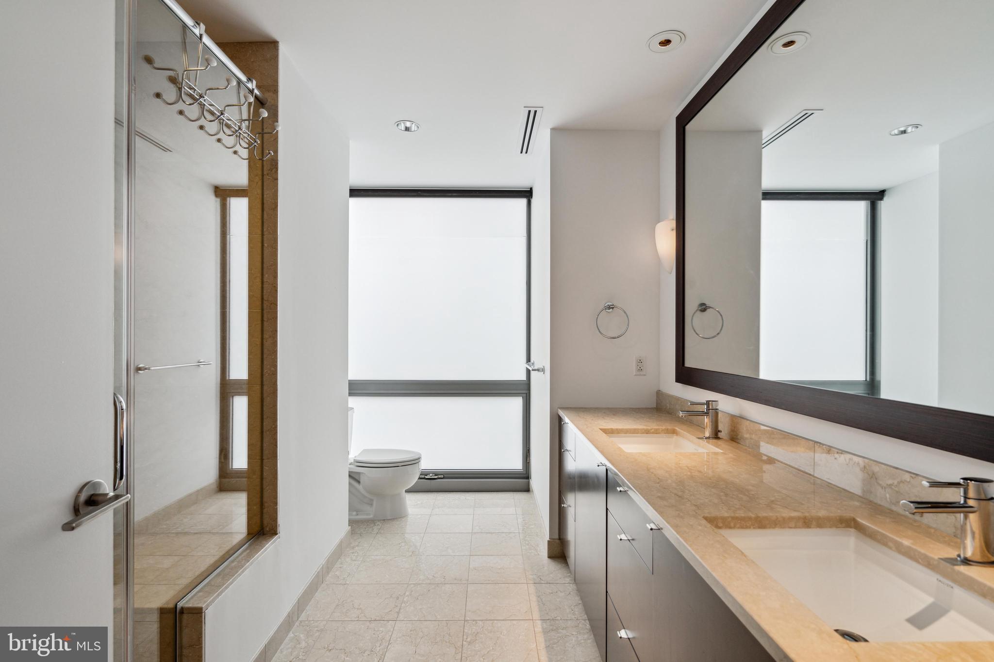1706 Rittenhouse Square, Unit 402 Philadelphia, PA 19103 - Photo 14 of 27 a bathroom with a granite countertop sink mirror and a bathtub