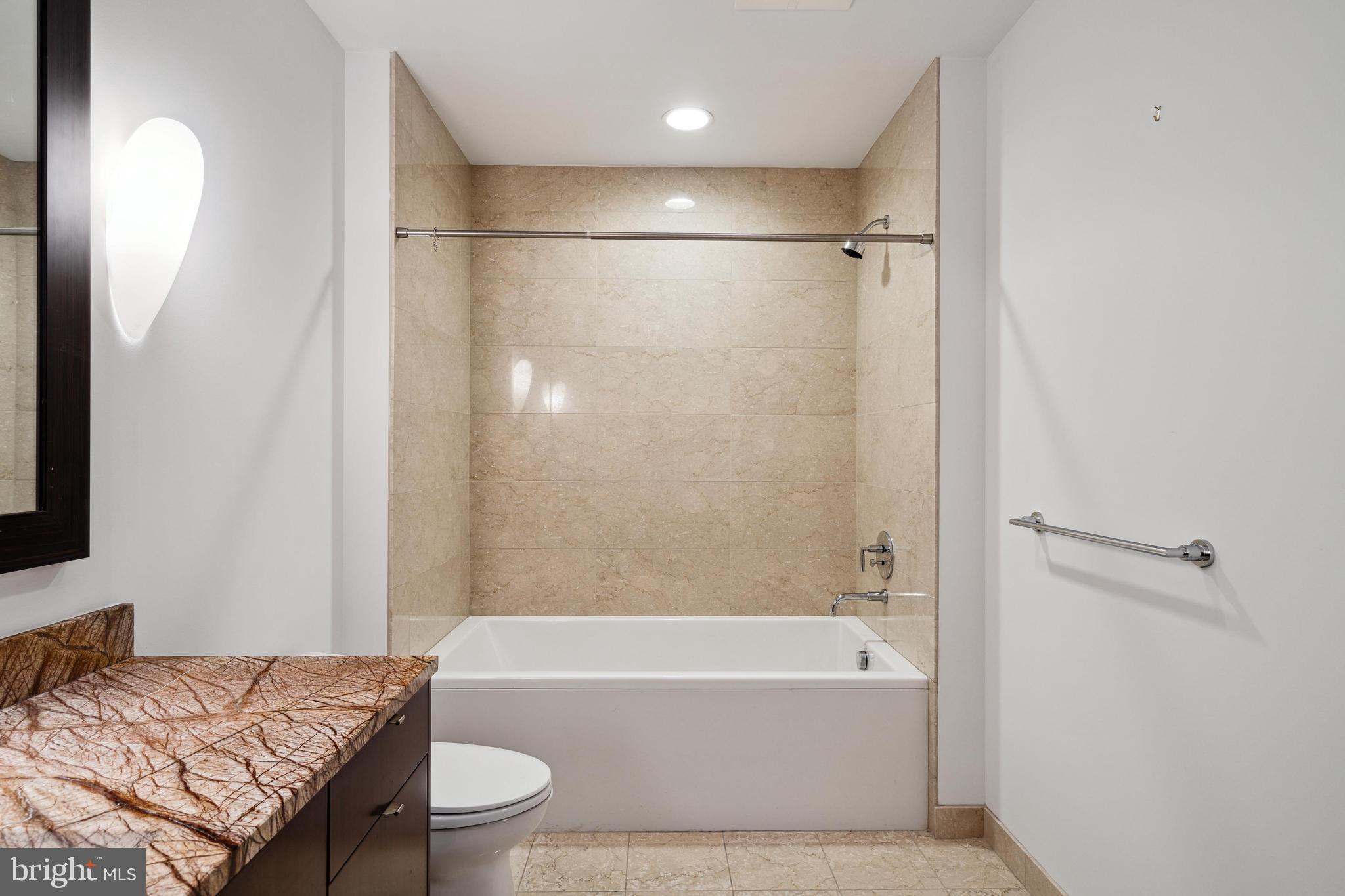 1706 Rittenhouse Square, Unit 402 Philadelphia, PA 19103 - Photo 19 of 27 a bathroom with a granite countertop bathtub shower sink vanity and toilet