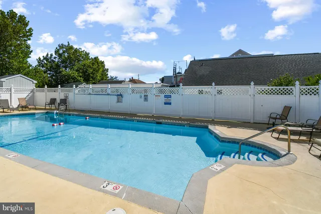 a view of a swimming pool with a patio and a yard