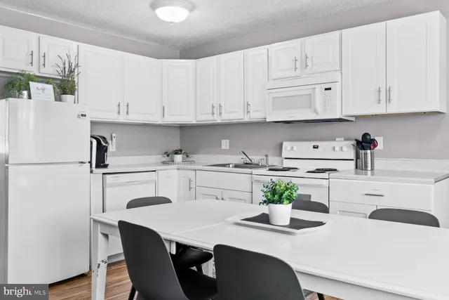 a kitchen with stainless steel appliances white cabinets and a refrigerator