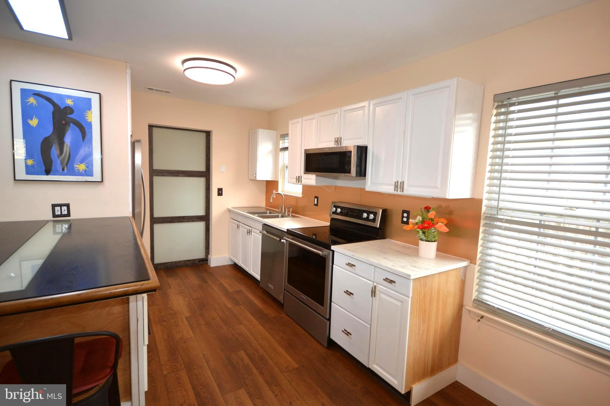 106 B Conner Street St. Michaels, MD 21663 - Photo 8 of 27 a kitchen with stainless steel appliances a stove refrigerator sink and microwave