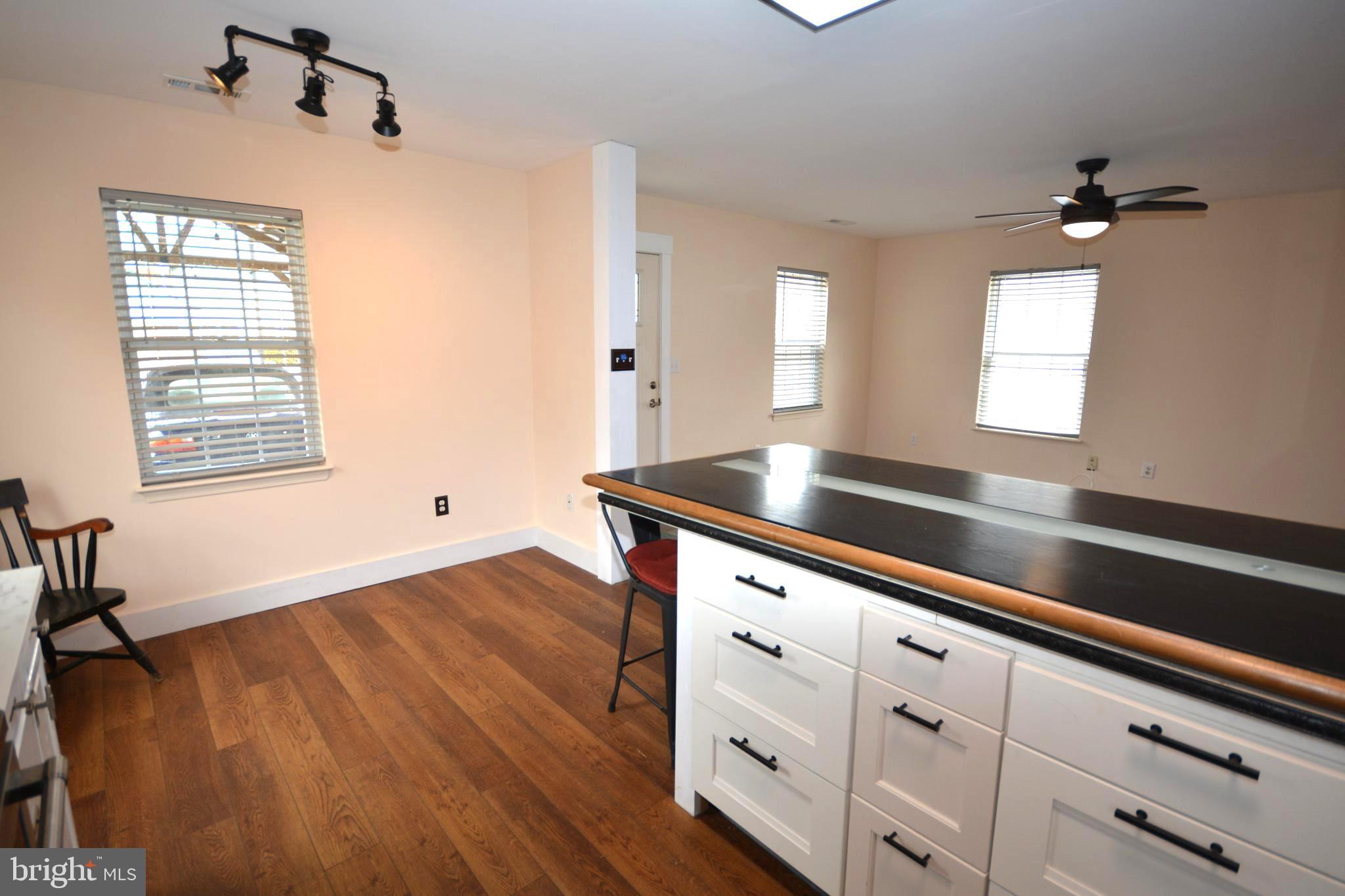 106 B Conner Street St. Michaels, MD 21663 - Photo 10 of 27 a kitchen with granite countertop white cabinets and wooden floor