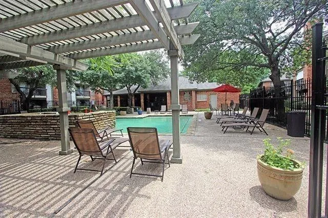 a view of a patio with a dining table and chairs with a small yard