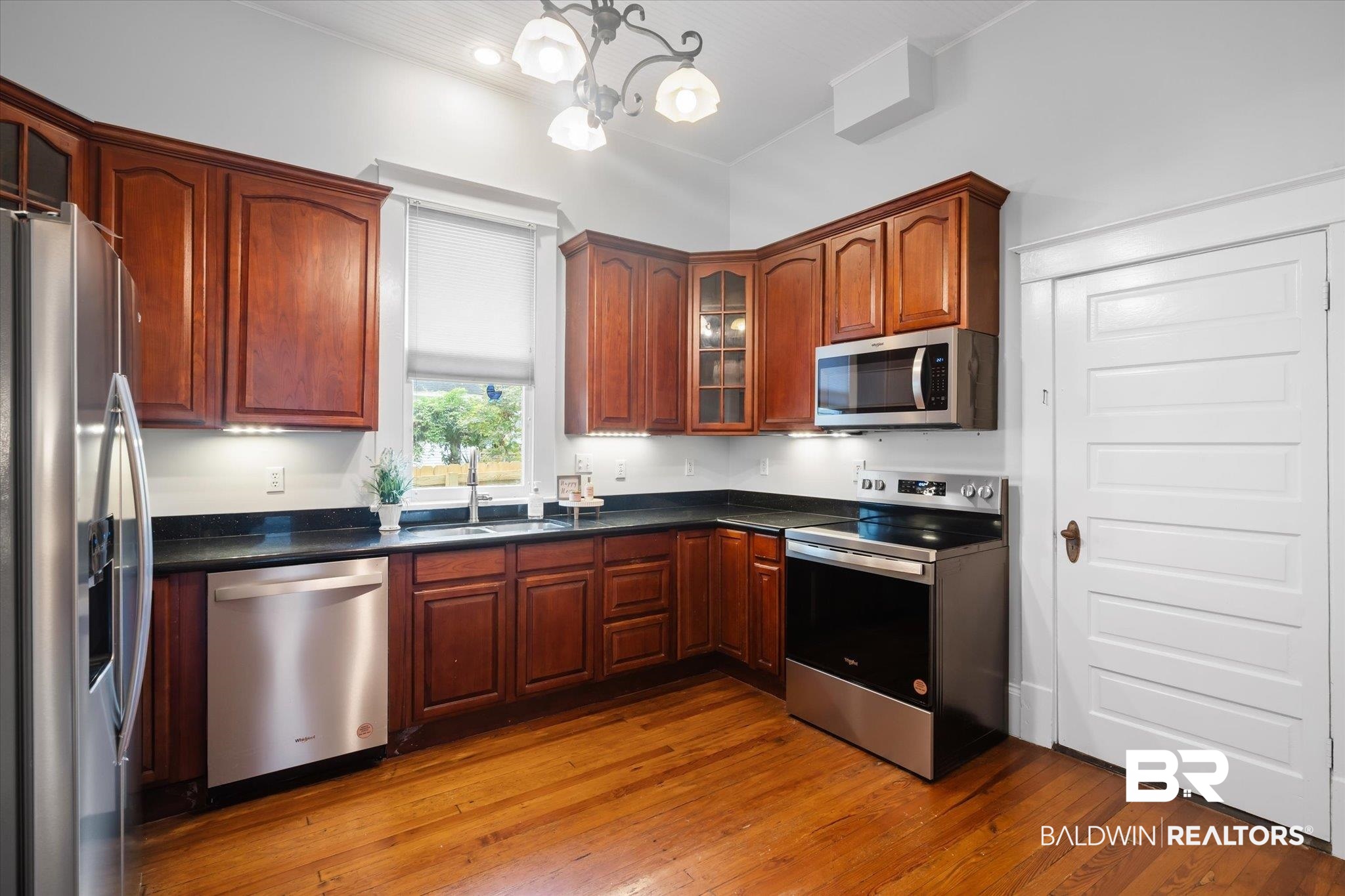 14 South Monterey Street Mobile, AL 36604 - Photo 9 of 41 Kitchen with stainless steel appliances, wood-type flooring, sink, and a chandelier