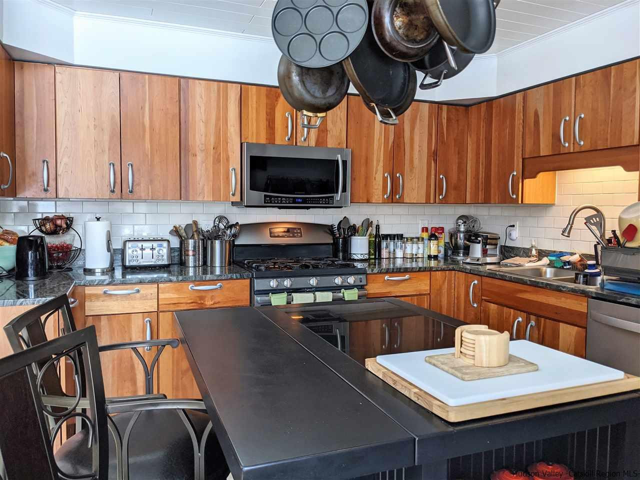 430 North Riverside Road Highland, NY 12528 - Photo 6 of 34 a kitchen with stainless steel appliances granite countertop a stove top oven a refrigerator a sink a dining table and chairs with wooden floor