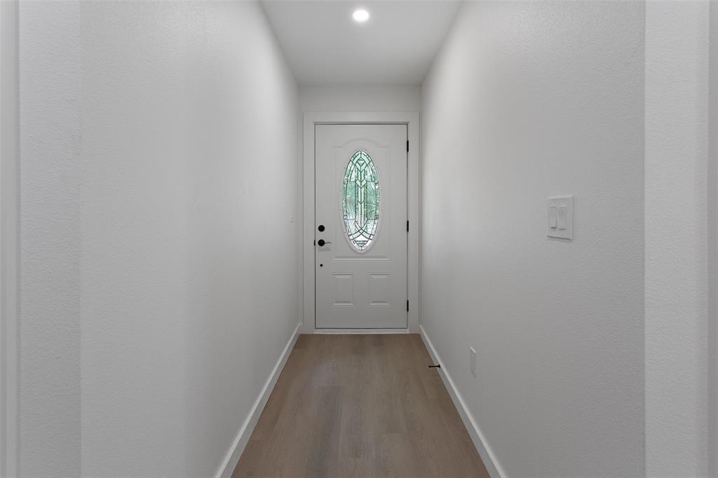 1346 South Reno Road Springtown, TX 76082 - Photo 18 of 24 Entryway featuring a white door with an oval decorative glass insert, recessed ceiling lighting, light wood-finish flooring, and white baseboards