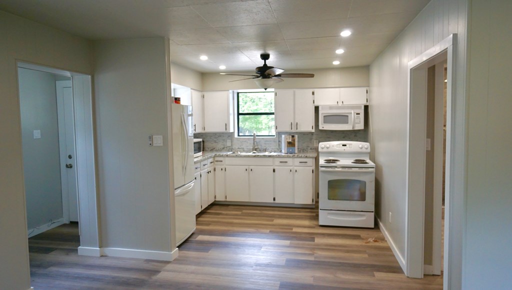 110 4th Street Ingram, TX 78025 - Photo 8 of 15 a kitchen with white cabinets and stainless steel appliances