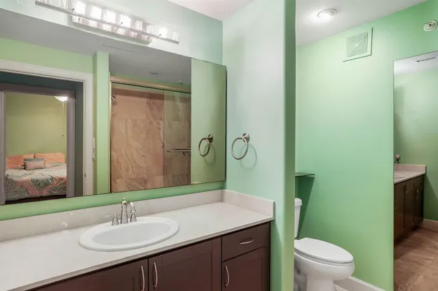 a bathroom with a granite countertop sink toilet and shower