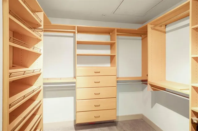 a view of walk in closet with empty racks