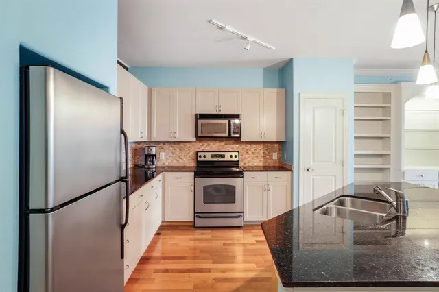 a kitchen with granite countertop a refrigerator and a sink