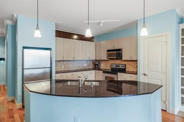 a kitchen with kitchen island a sink a microwave a stove and refrigerator