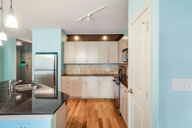 a kitchen with a refrigerator sink and cabinets