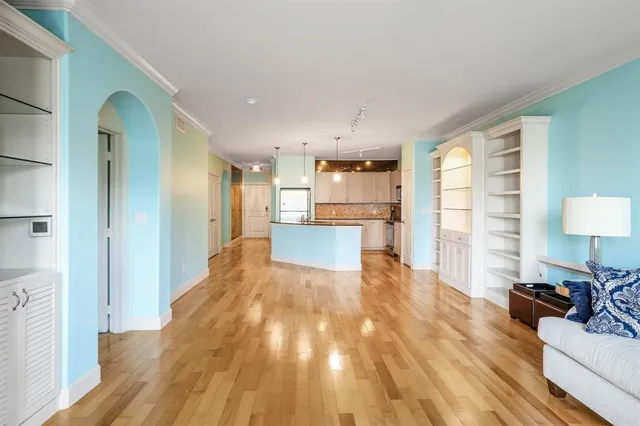 a view of a living room a wooden floor and a kitchen