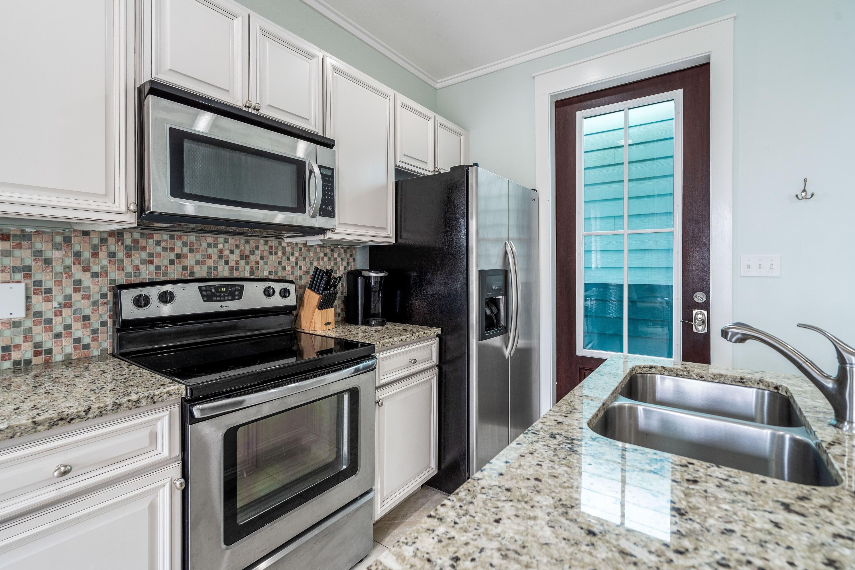 36 Moonlight Beach Lane Inlet Beach, FL 32461 - Photo 42 of 42 a kitchen with stainless steel appliances granite countertop a stove microwave and refrigerator