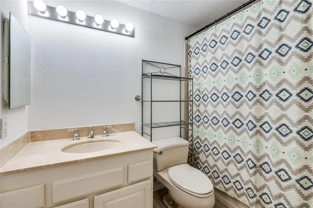 a view of an empty room with wooden floor fireplace and a window