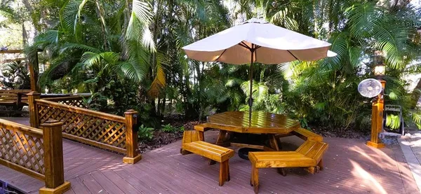 an outdoor sitting area with chairs and wooden fence