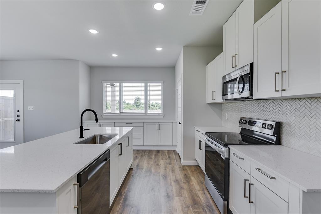 4220 Clovis Street Midlothian, TX 76065 - Photo 10 of 19 a kitchen with kitchen island a sink appliances cabinets and a counter top space