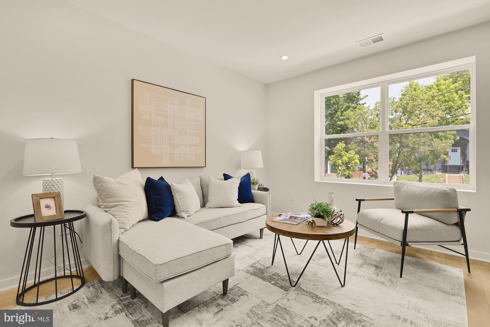 a living room with furniture a table and a large window