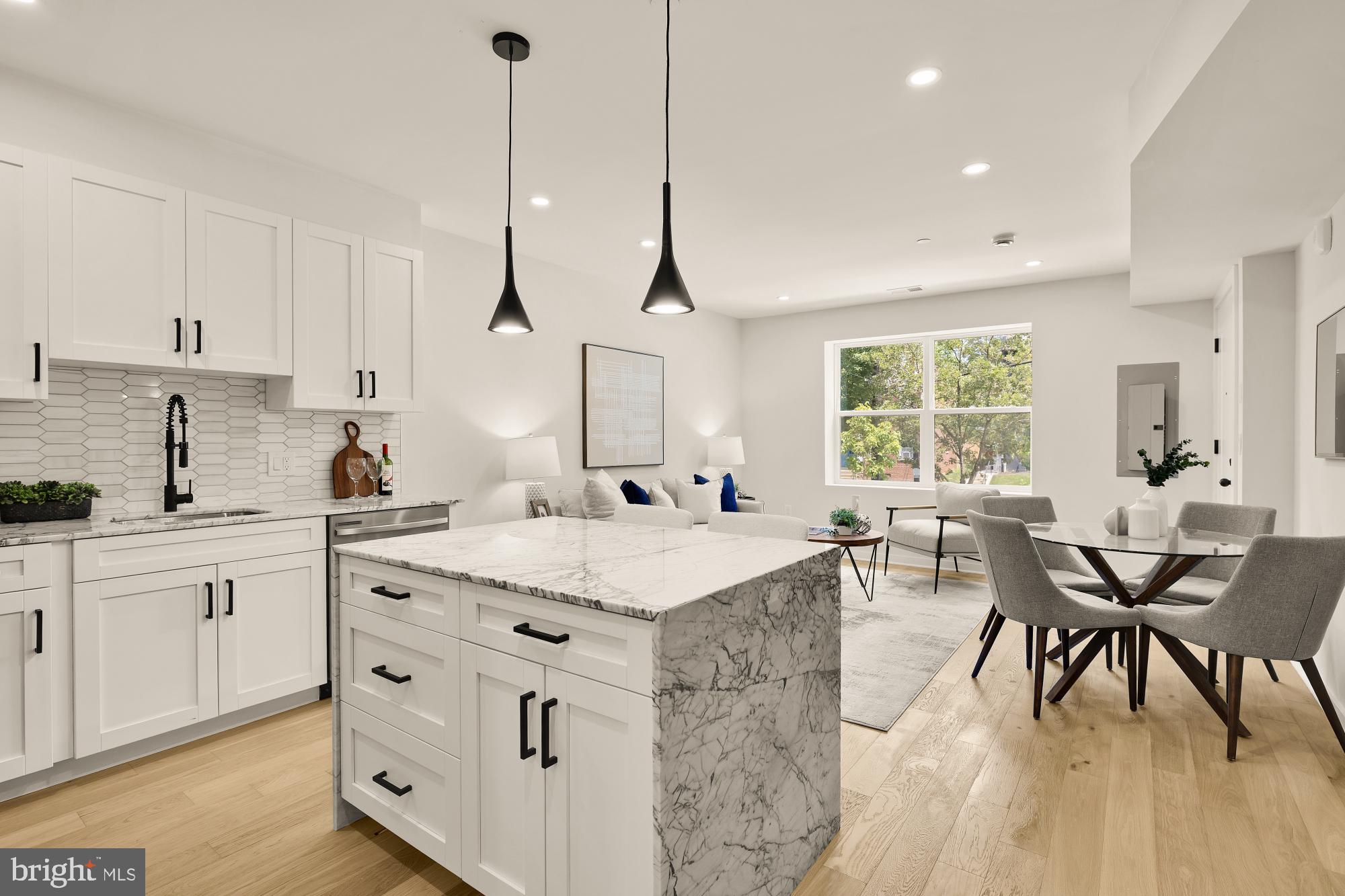 2606 41st Street Northwest, Unit 4 Washington, DC 20007 - Photo 12 of 25 a open kitchen with stainless steel appliances granite countertop a sink a stove a dining table and chairs with wooden floor