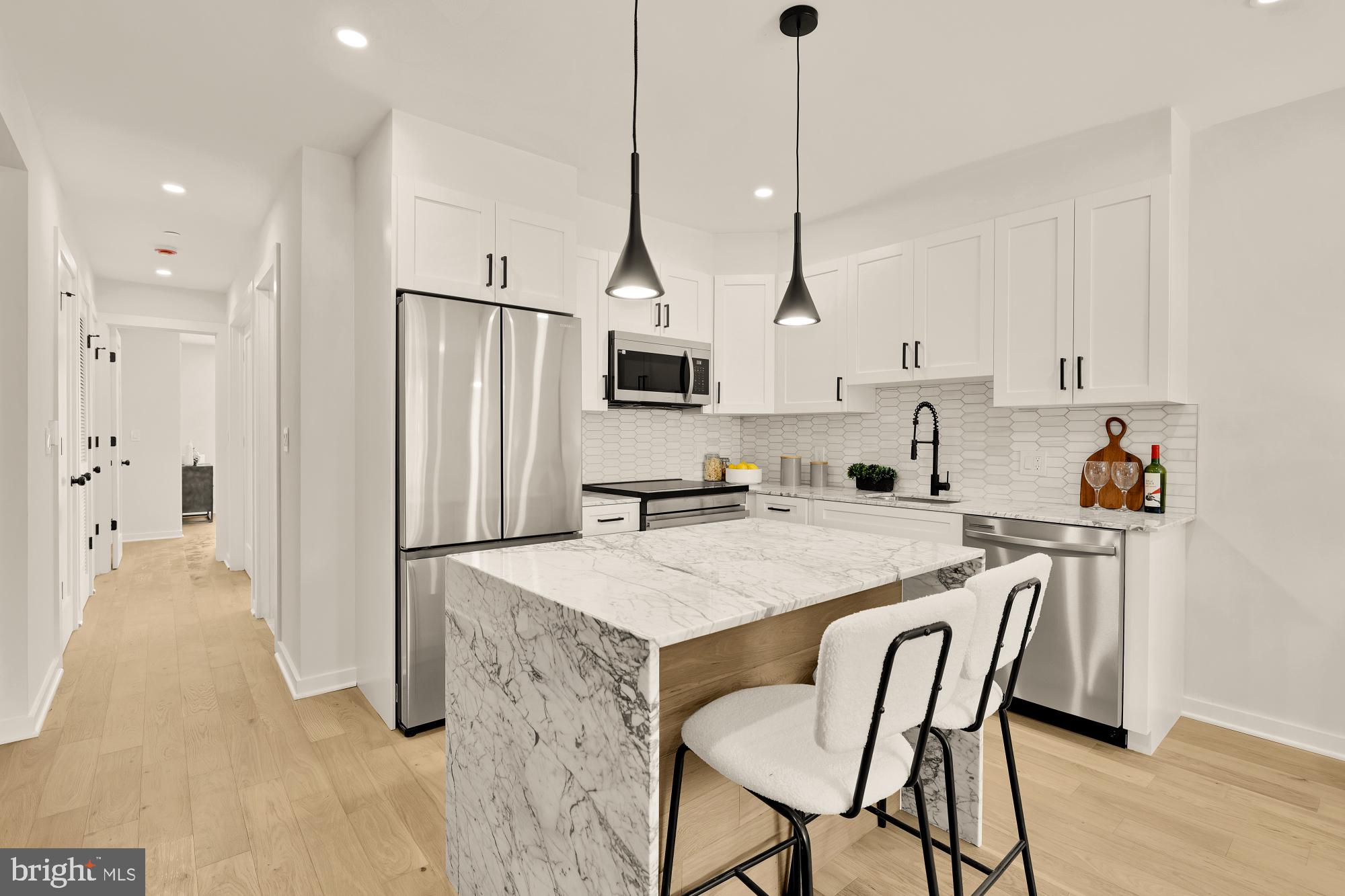 2606 41st Street Northwest, Unit 4 Washington, DC 20007 - Photo 5 of 25 a kitchen with stainless steel appliances granite countertop a sink a stove a refrigerator and white cabinets