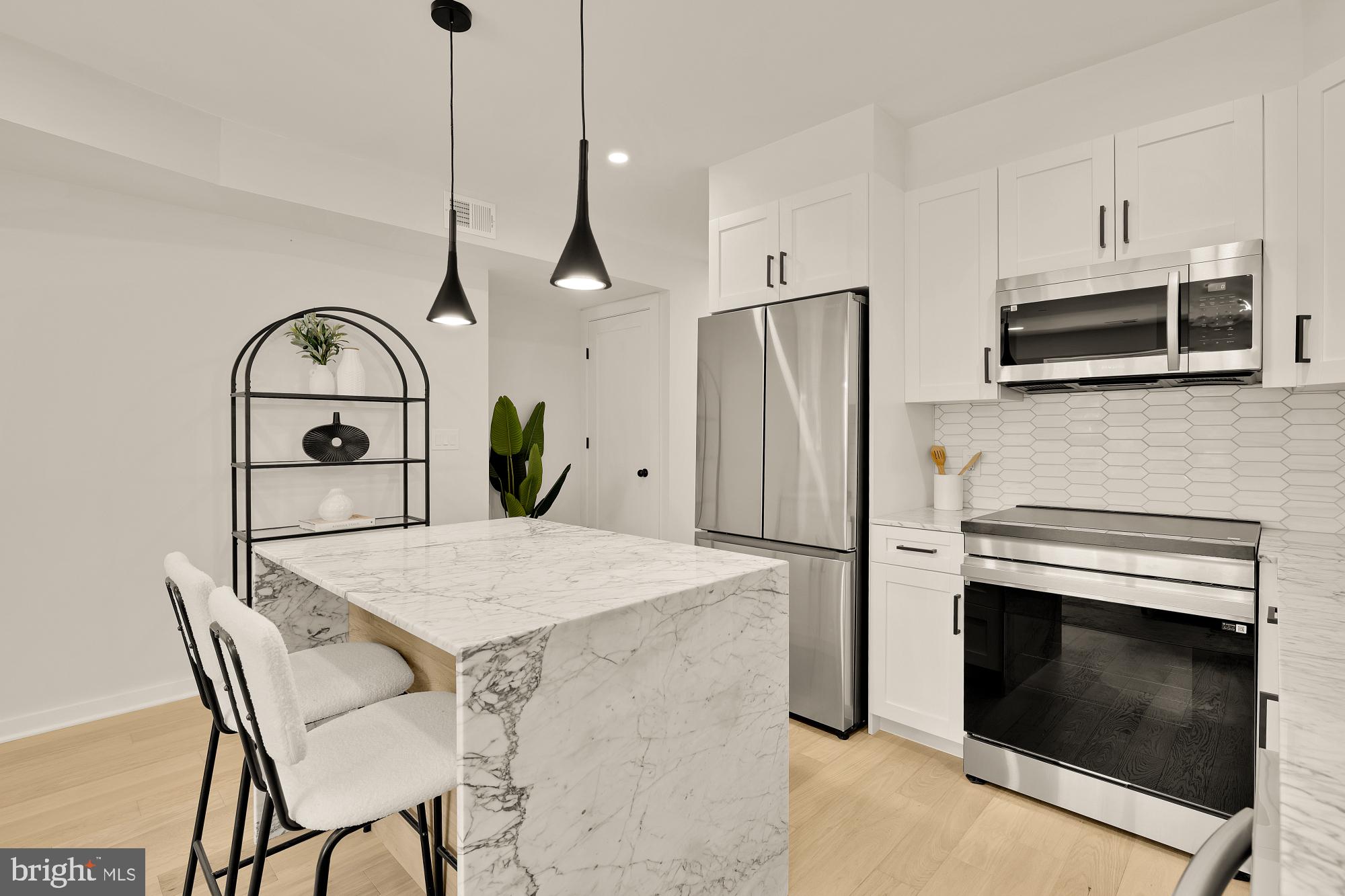2606 41st Street Northwest, Unit 4 Washington, DC 20007 - Photo 7 of 25 a kitchen with stainless steel appliances kitchen island a table chairs and microwave