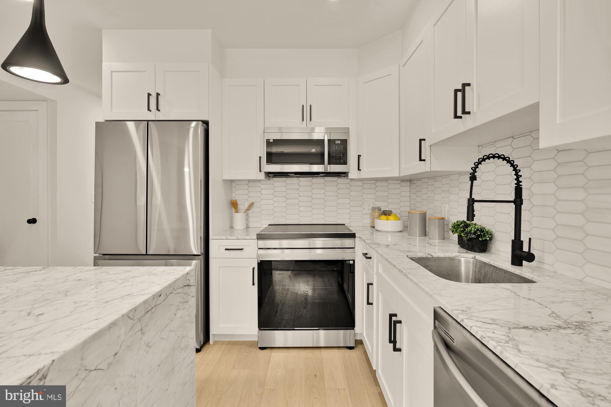 2606 41st Street Northwest, Unit 4 Washington, DC 20007 - Photo 8 of 25 a kitchen with stainless steel appliances granite countertop a sink stove and refrigerator