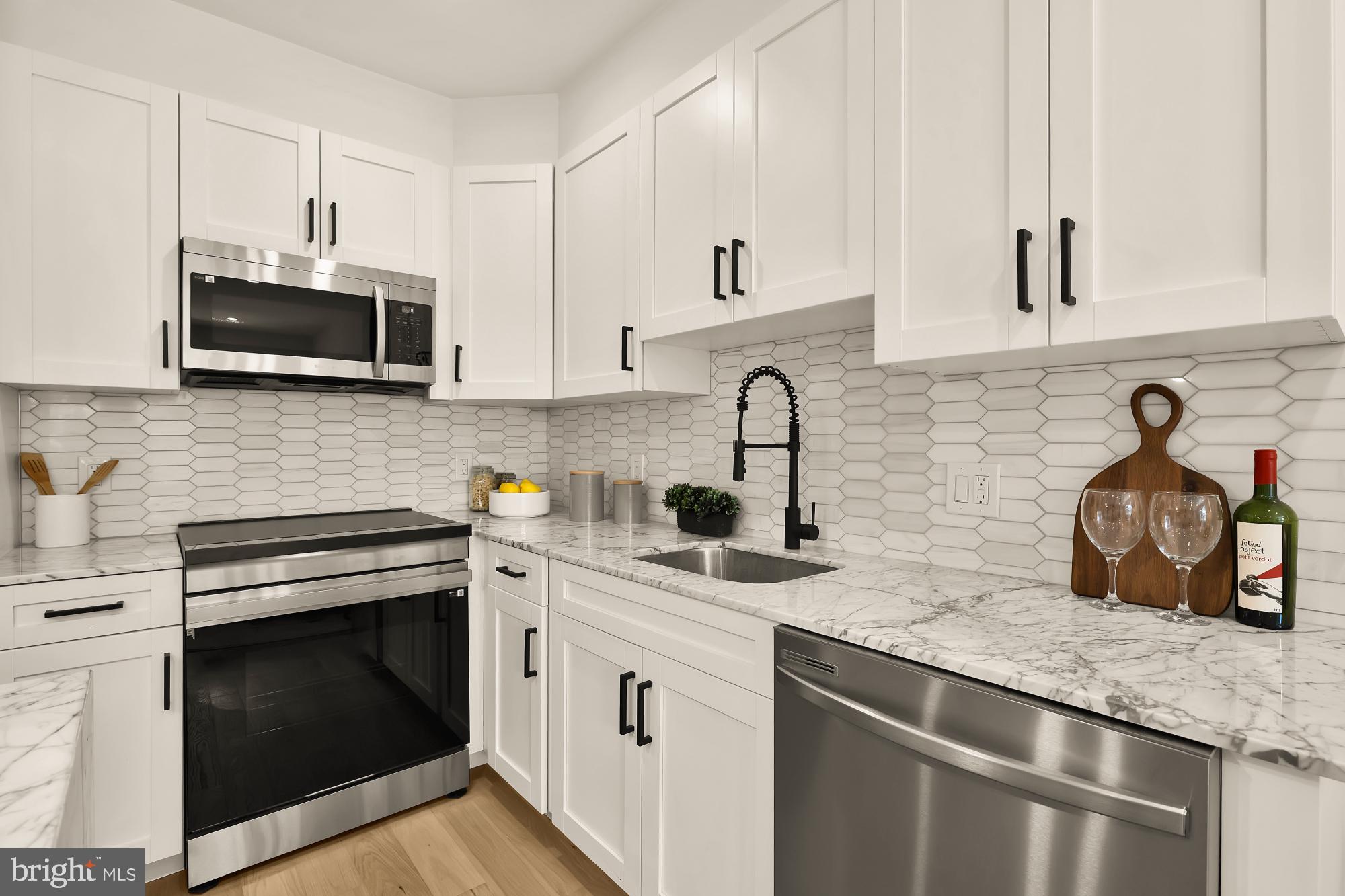 2606 41st Street Northwest, Unit 4 Washington, DC 20007 - Photo 9 of 25 a kitchen with stainless steel appliances granite countertop a sink stove and microwave