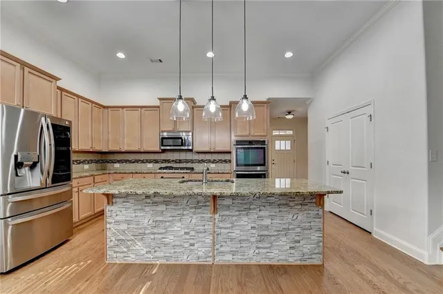 a kitchen with kitchen island a counter top space appliances and cabinets