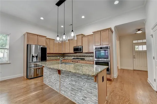 a large kitchen with a chandelier and wooden floor