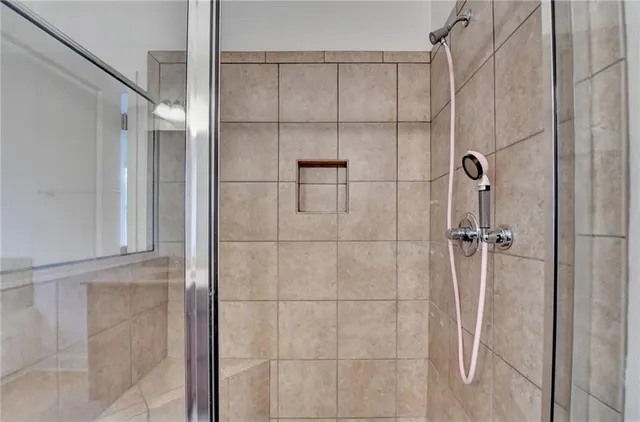 an empty room with chandelier fan and windows