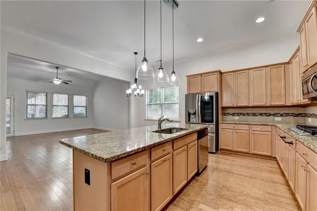 a kitchen with stainless steel appliances granite countertop a sink stove and refrigerator