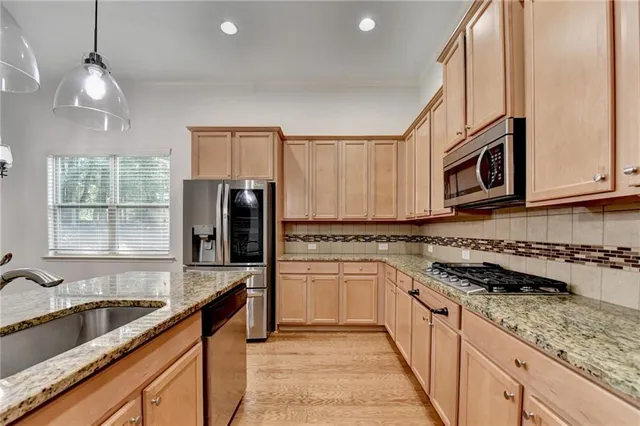a kitchen with granite countertop white cabinets and stainless steel appliances