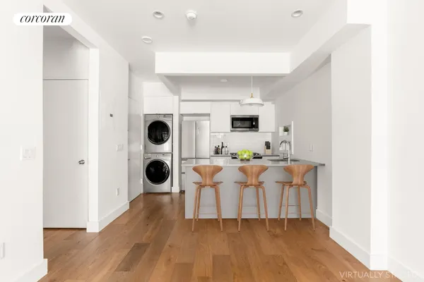 a view of kitchen with stainless steel appliances kitchen island granite countertop a refrigerator and a wooden floor