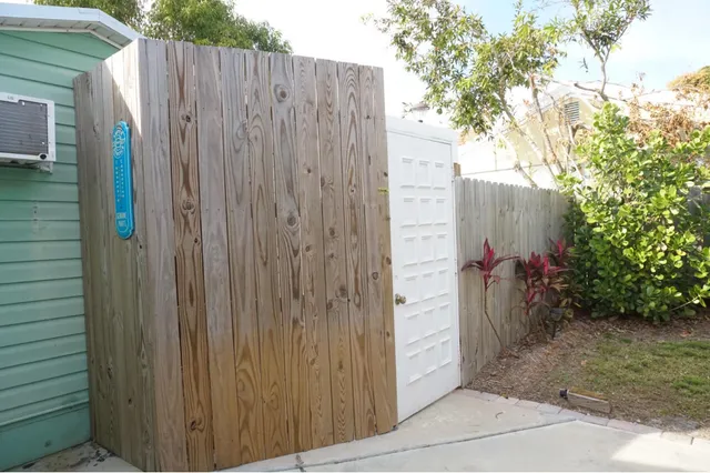 a view of a storage house and wooden fence