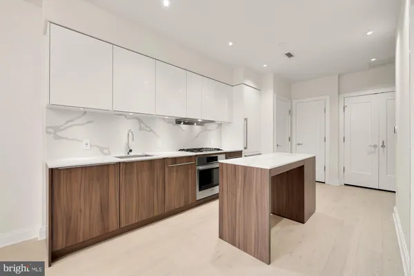 a kitchen with stainless steel appliances granite countertop a sink a stove and a refrigerator