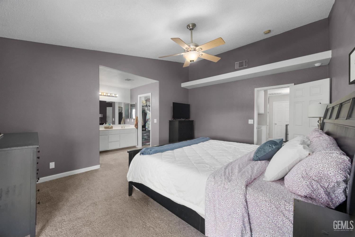 Undisclosed Address Bakersfield, CA 93312 - Photo 18 of 31 a spacious bedroom with a bed and a chandelier