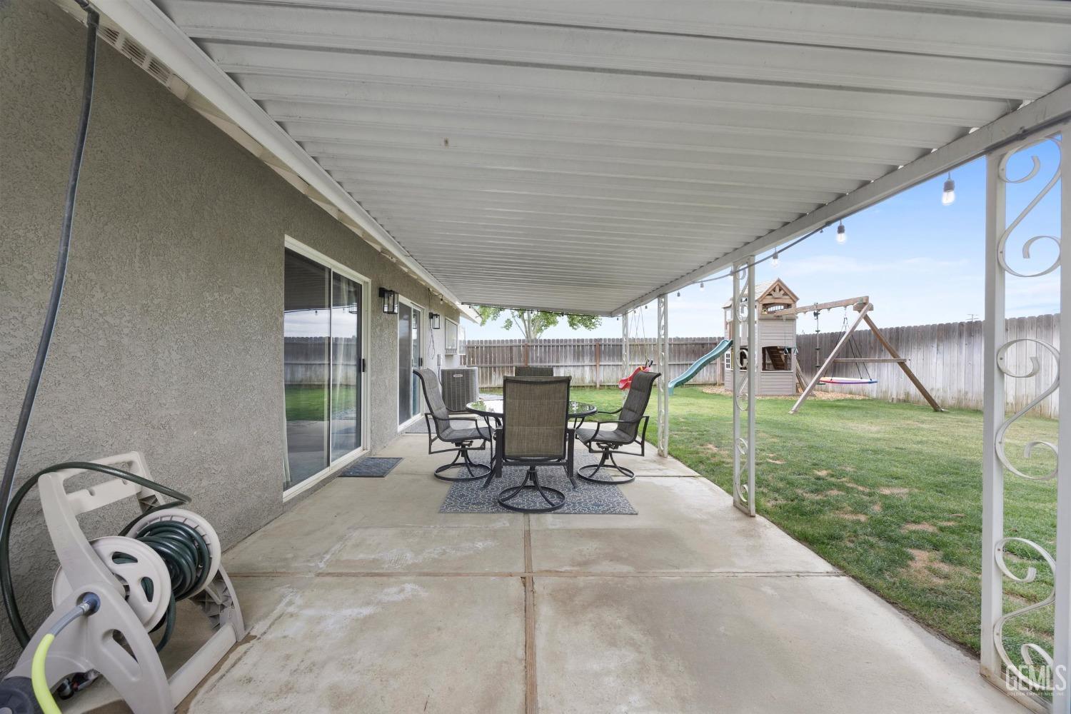 Undisclosed Address Bakersfield, CA 93312 - Photo 25 of 31 a view of a patio with table and chairs next to a yard
