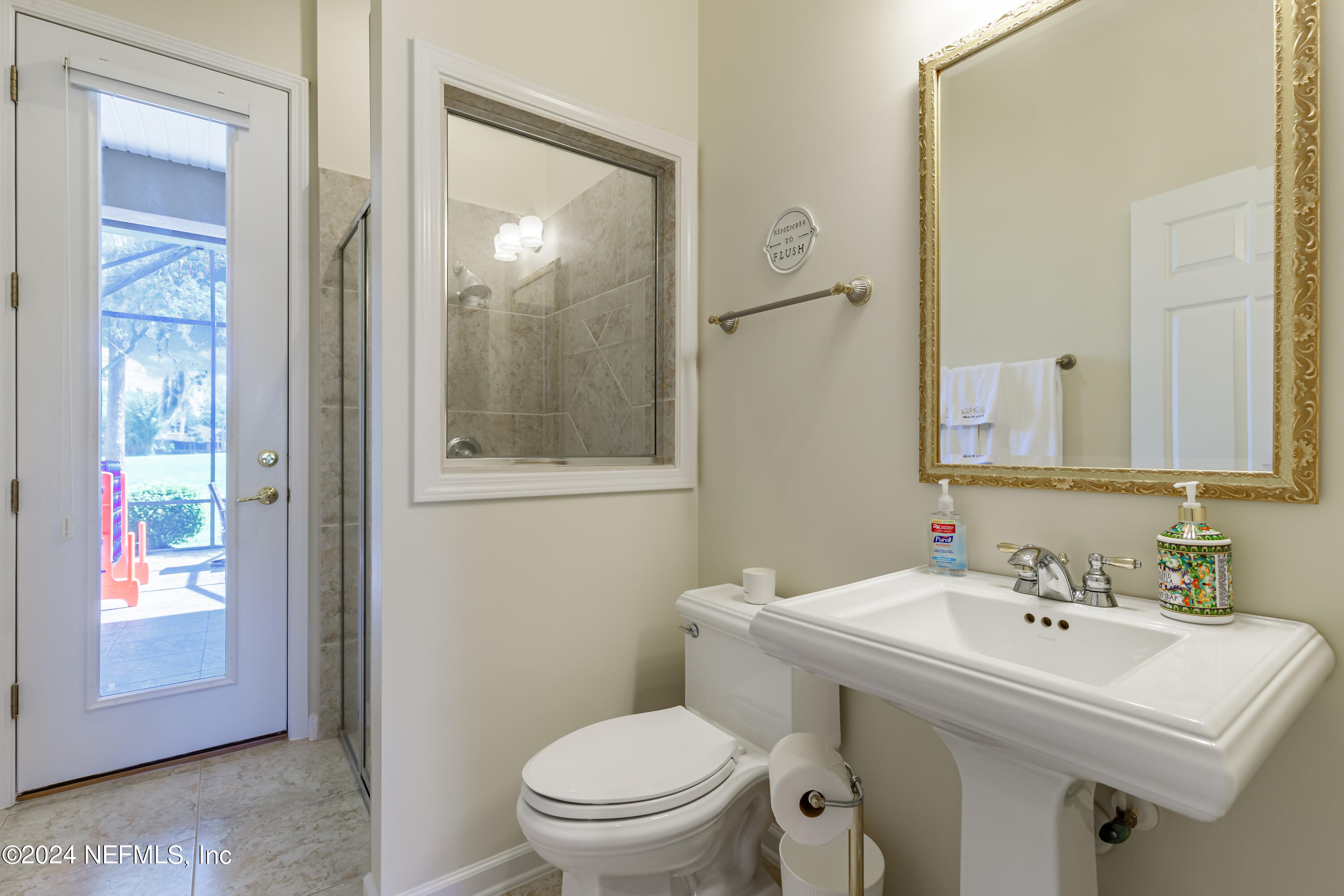2032 Rivergate Drive Fleming Island, FL 32003 - Photo 39 of 120 a bathroom with a sink toilet and mirror