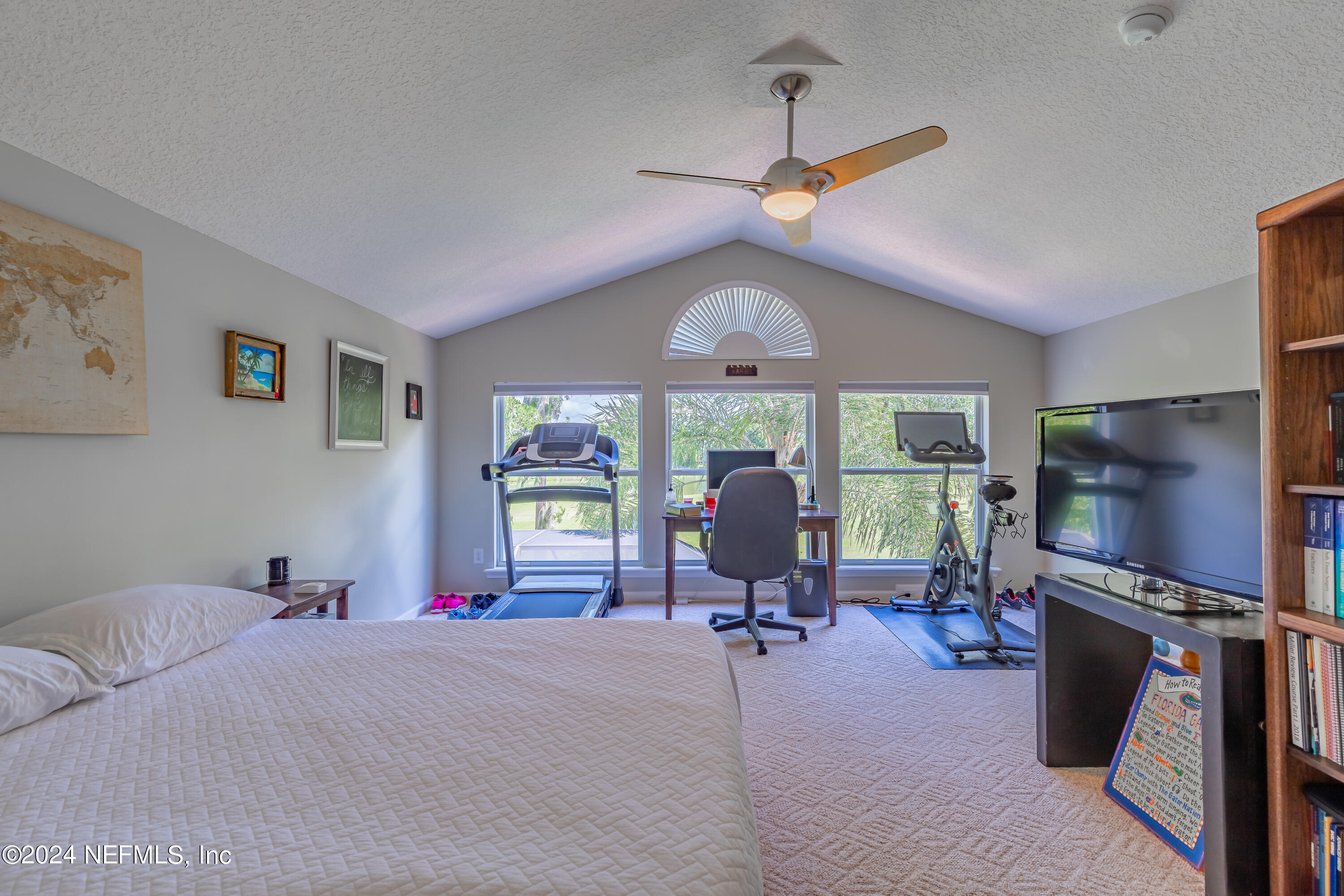 2032 Rivergate Drive Fleming Island, FL 32003 - Photo 40 of 120 a bedroom with furniture a flat screen tv and a ceiling fan