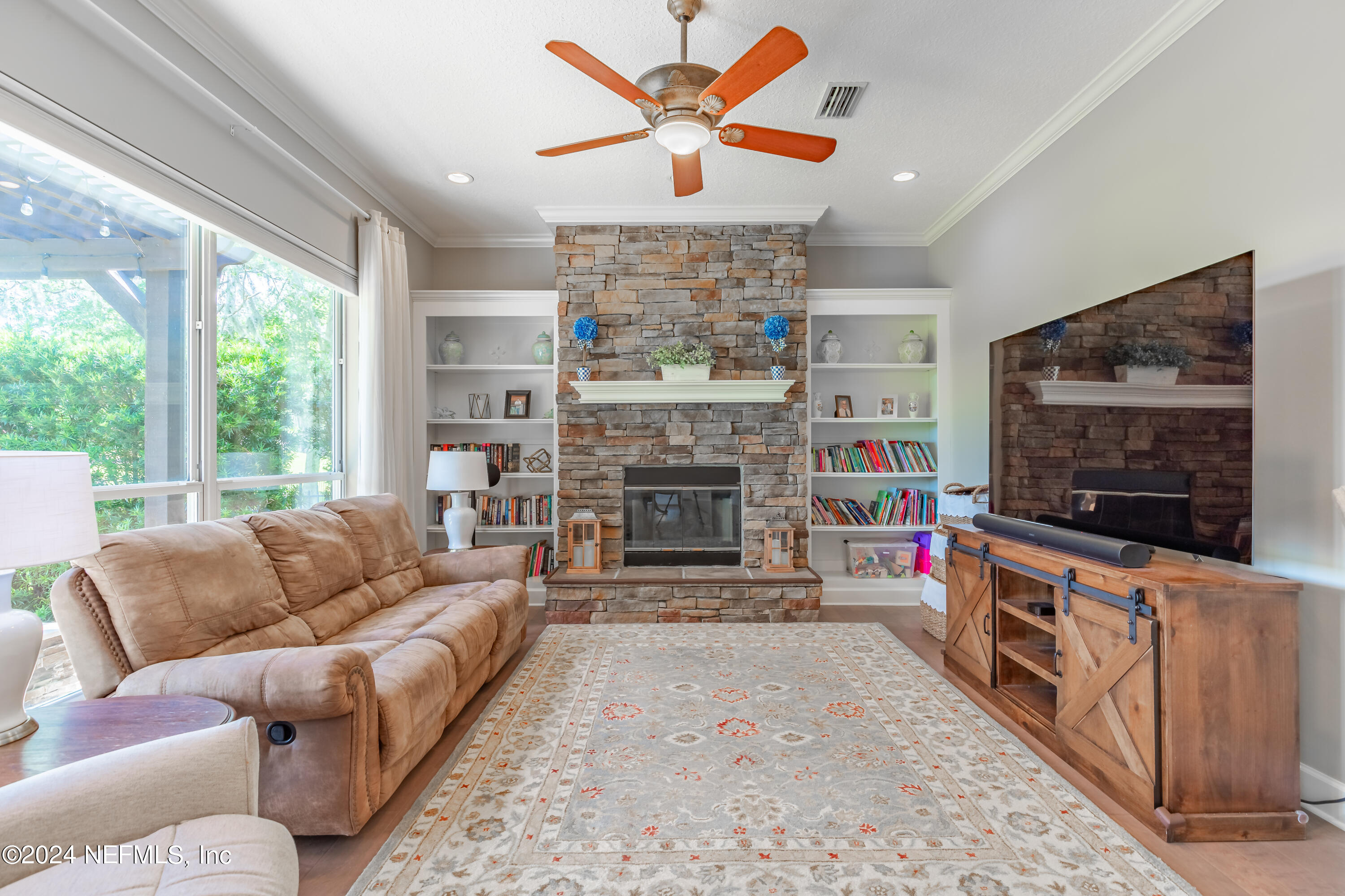 2032 Rivergate Drive Fleming Island, FL 32003 - Photo 9 of 120 a living room with furniture a flat screen tv and a fireplace