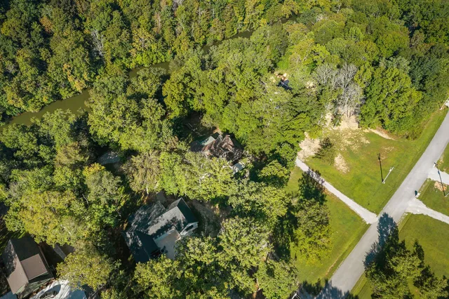 a living room with furniture floor to ceiling window and a wooden floor